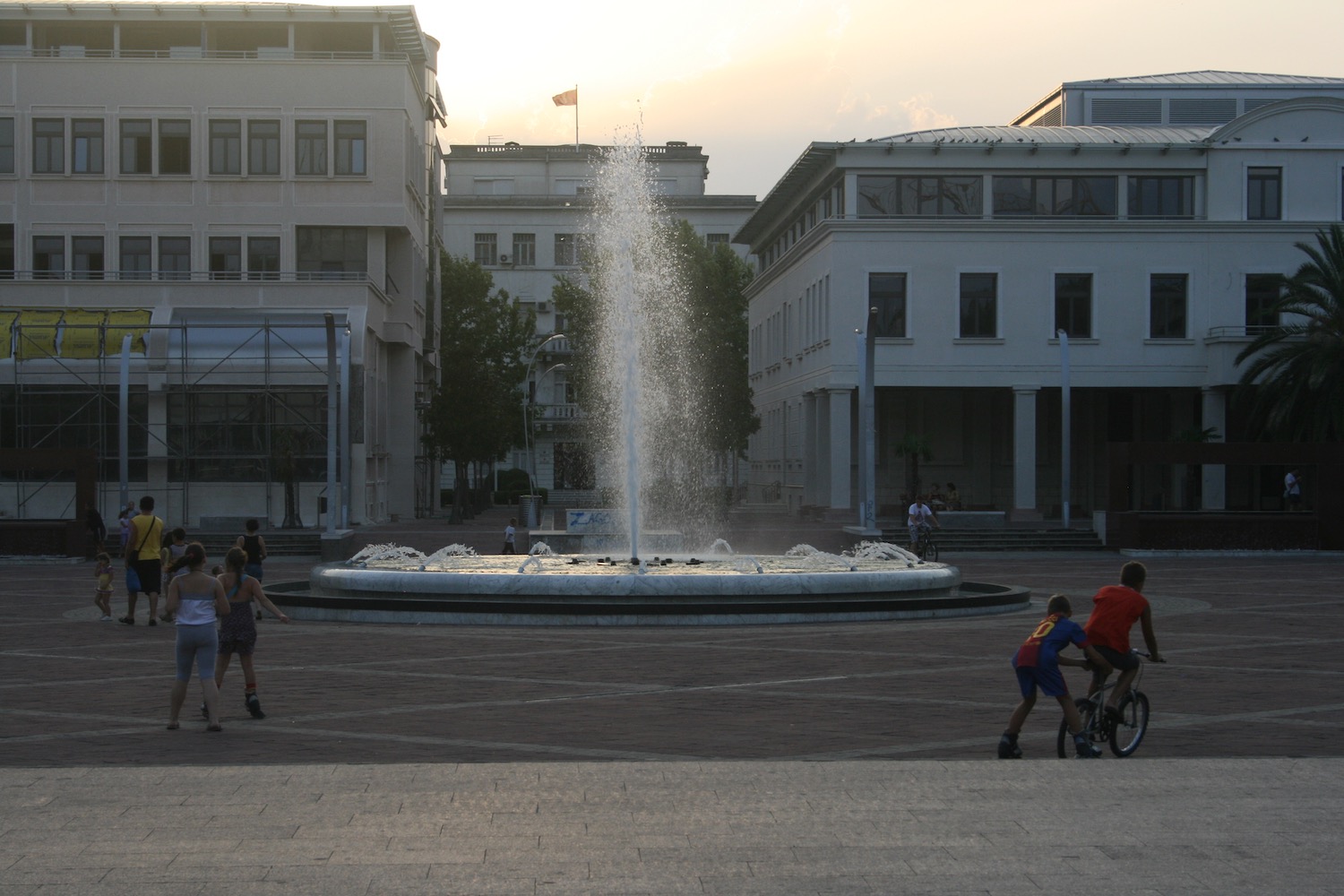 a fountain in a courtyard with people walking around