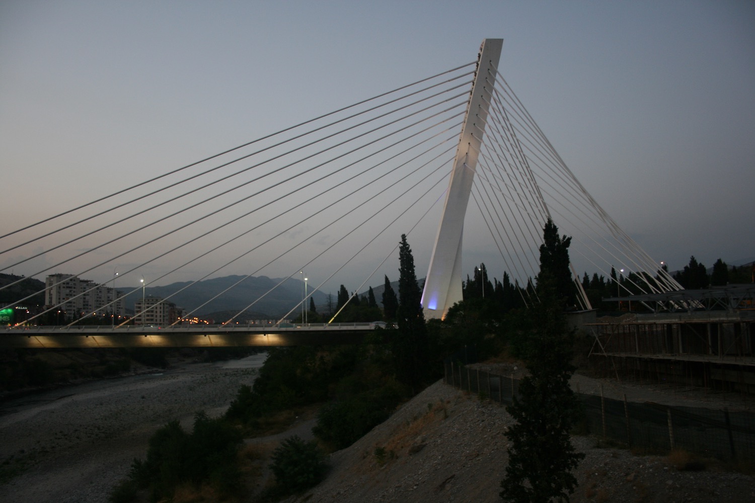 a bridge with cables and a river