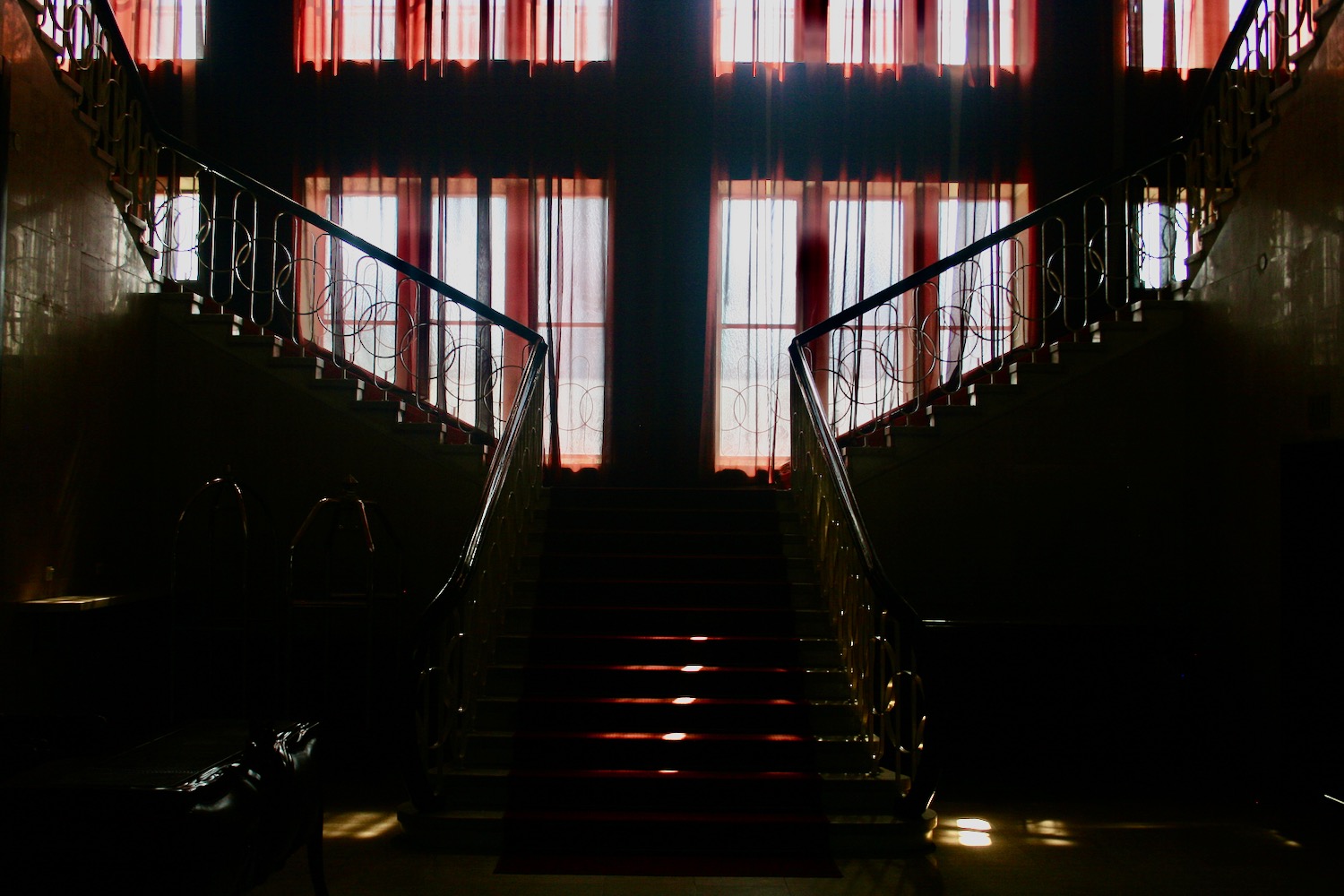 a staircase with red carpet and red curtains