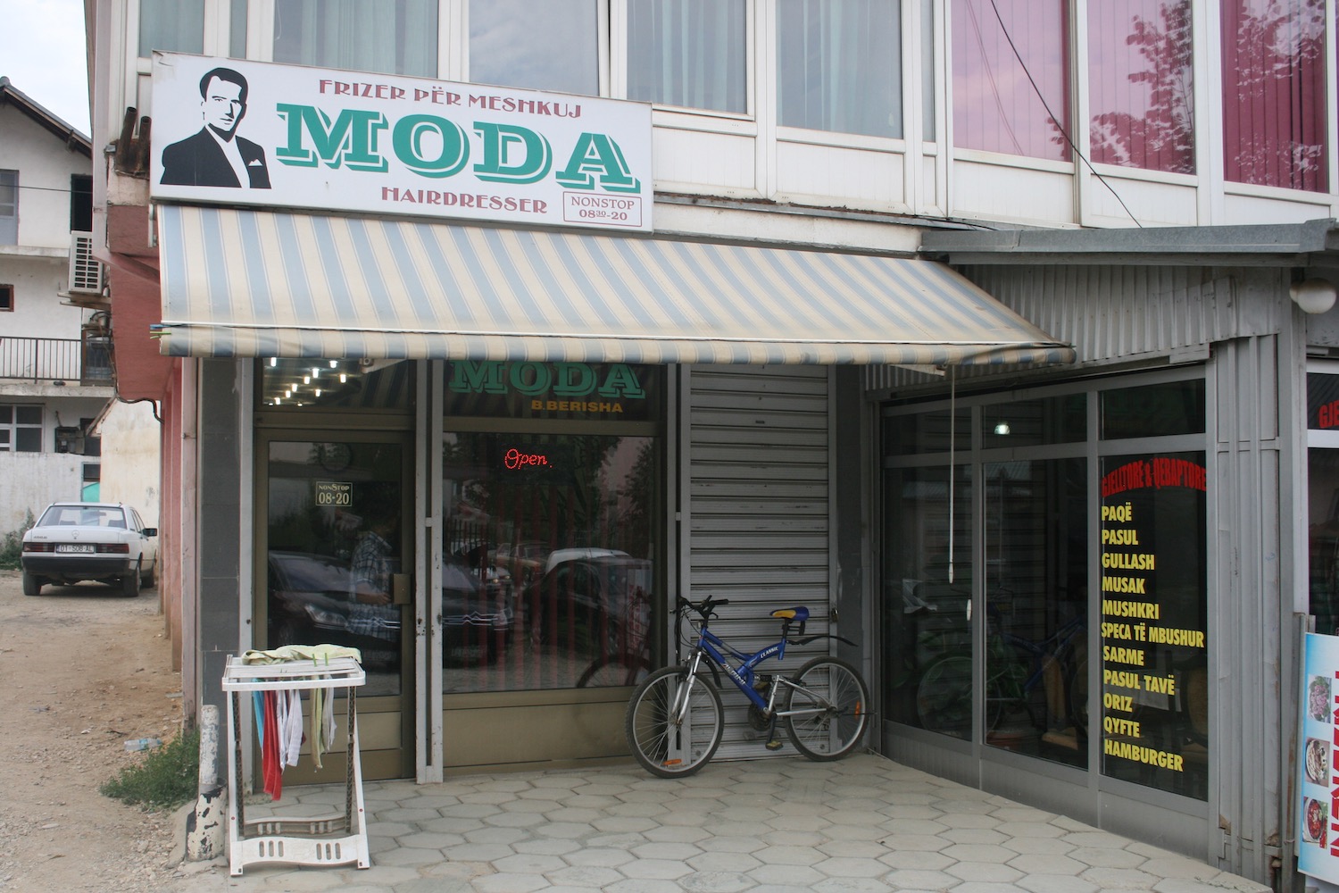 a bicycle parked outside of a hairdresser