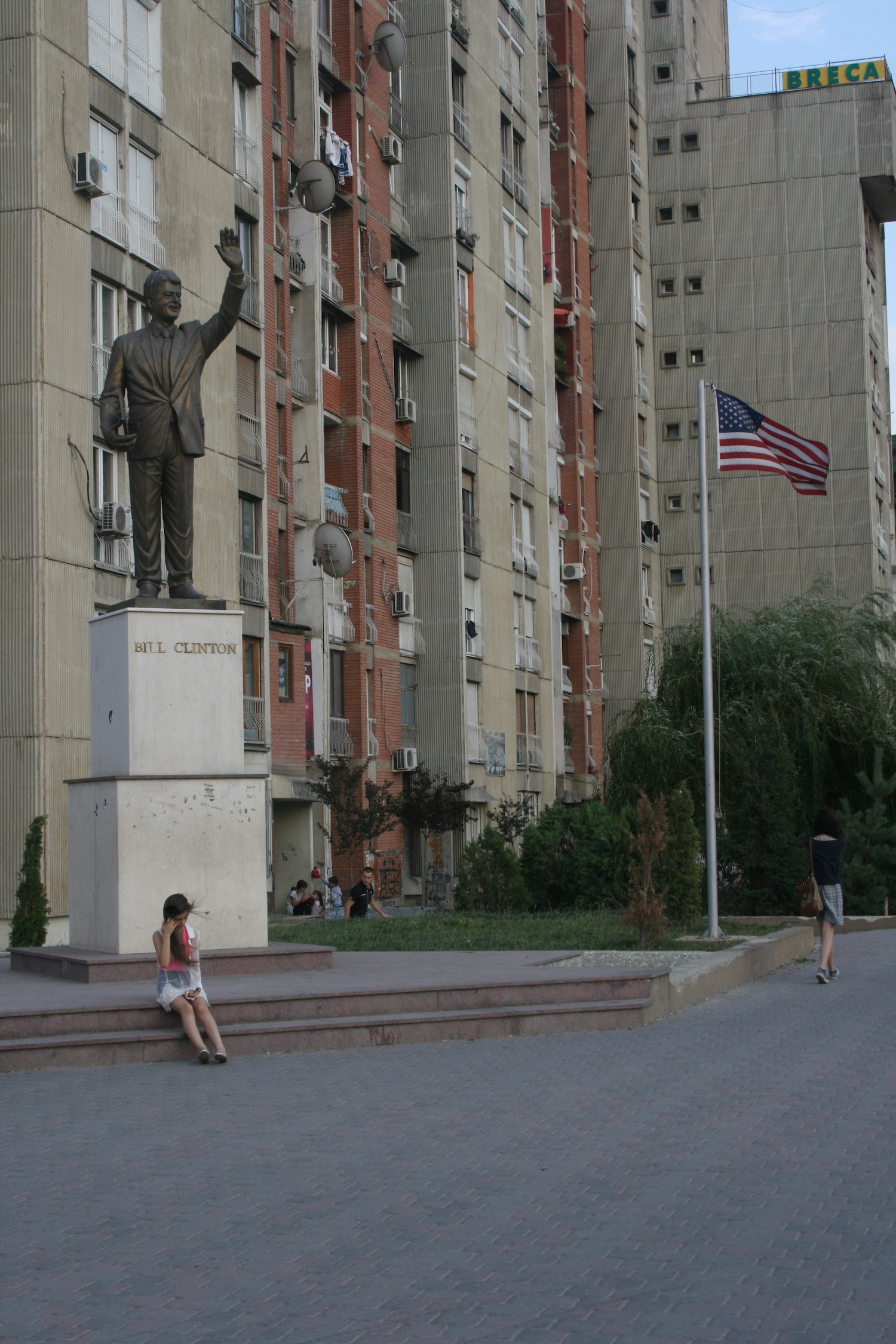 a statue of a man with a flag in front of a building