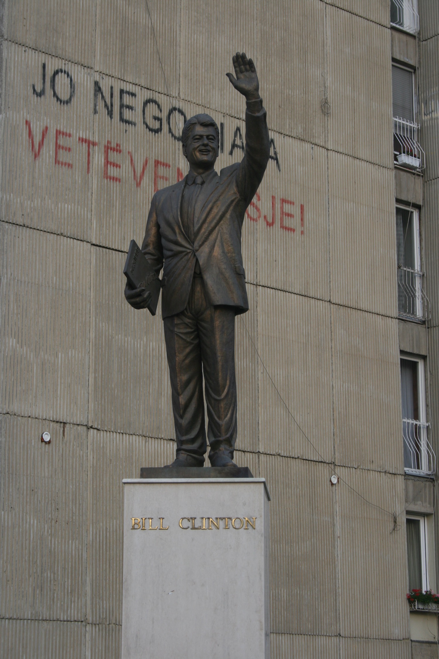 a statue of a man holding a book and a briefcase