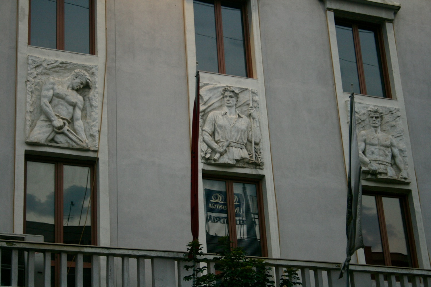 a building with a flag and statues on the side