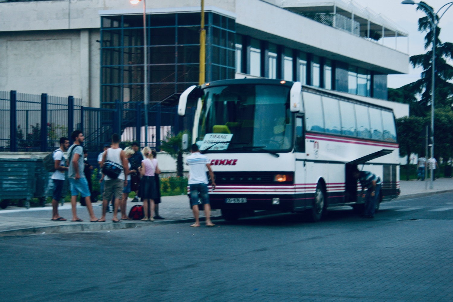 a group of people standing next to a bus