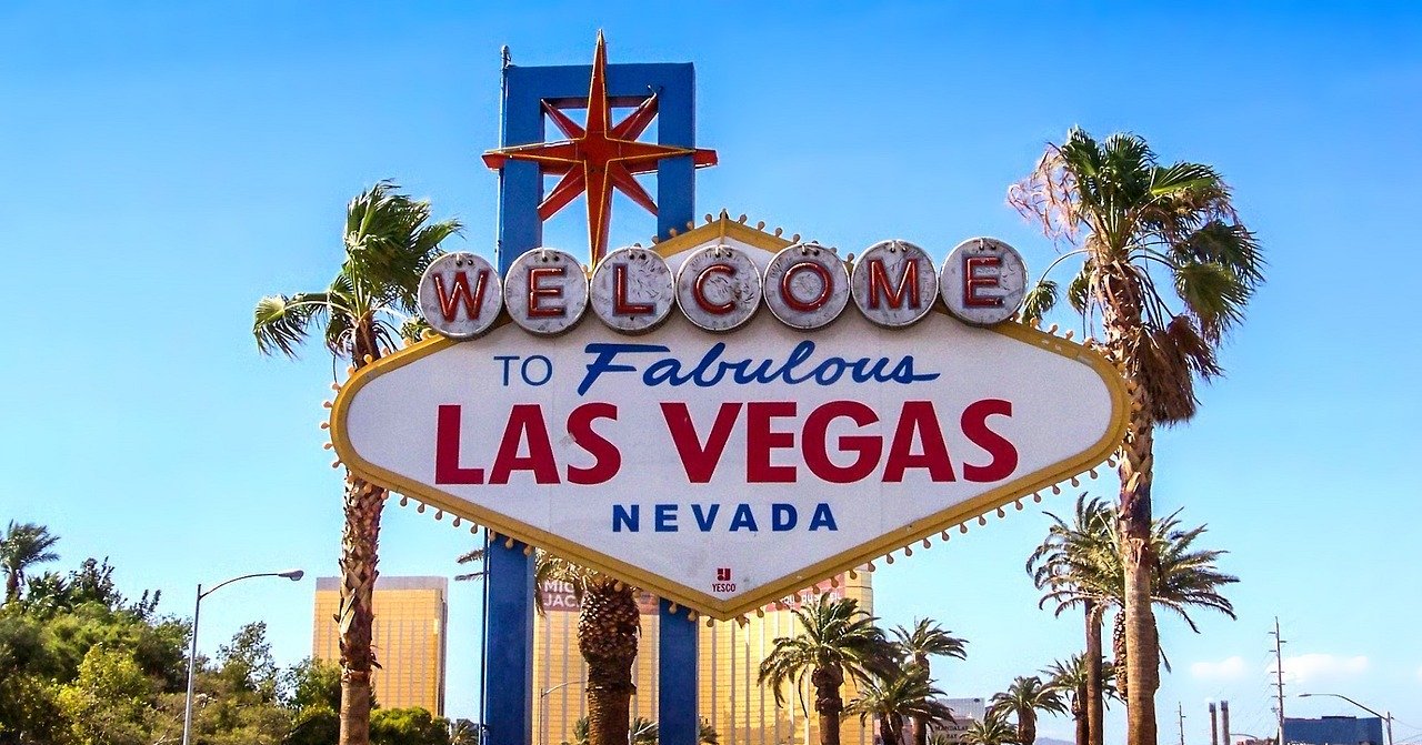 a sign with palm trees and a star on it with Welcome to Fabulous Las Vegas sign in the background