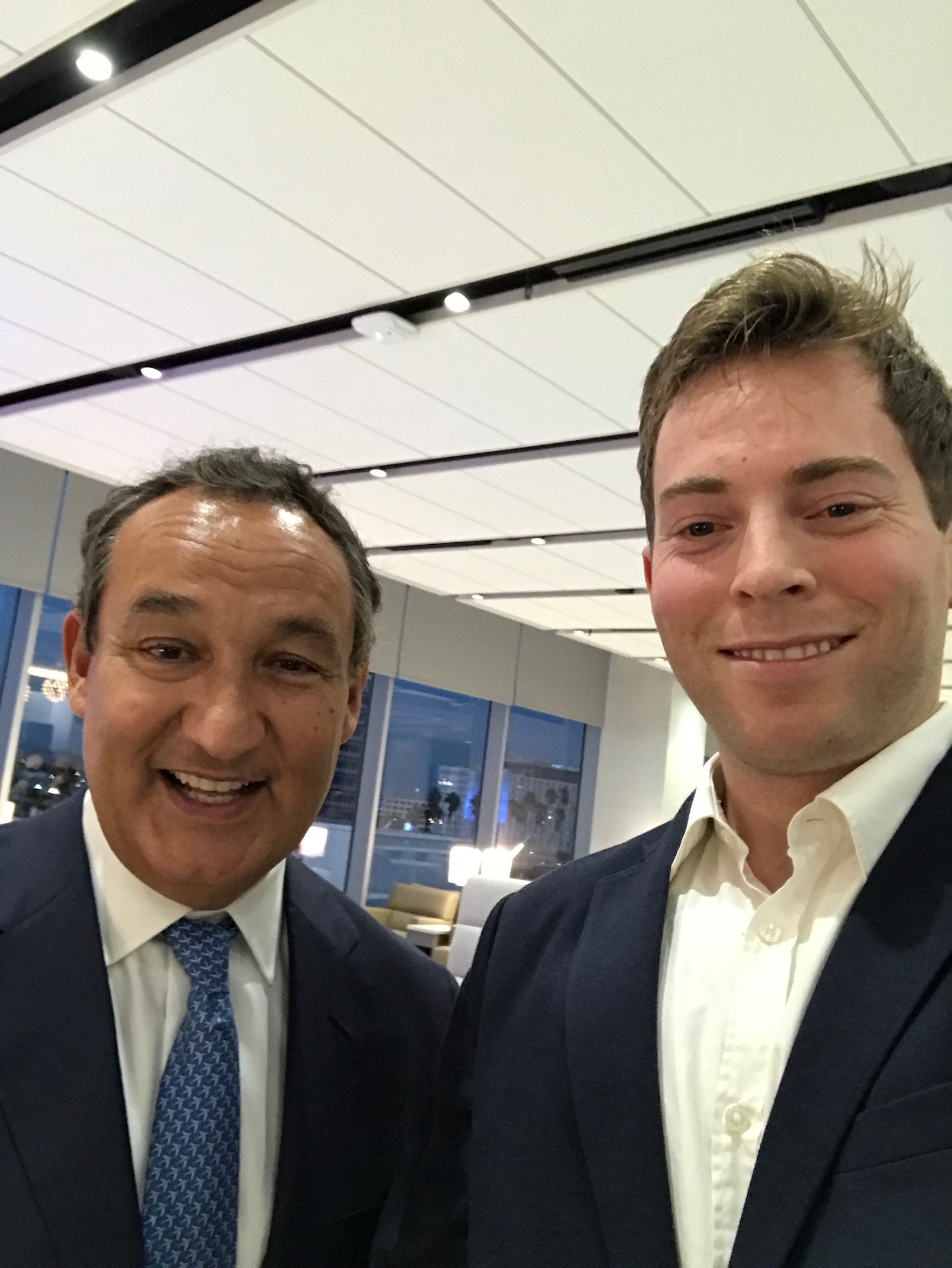 two men in suits smiling for a selfie