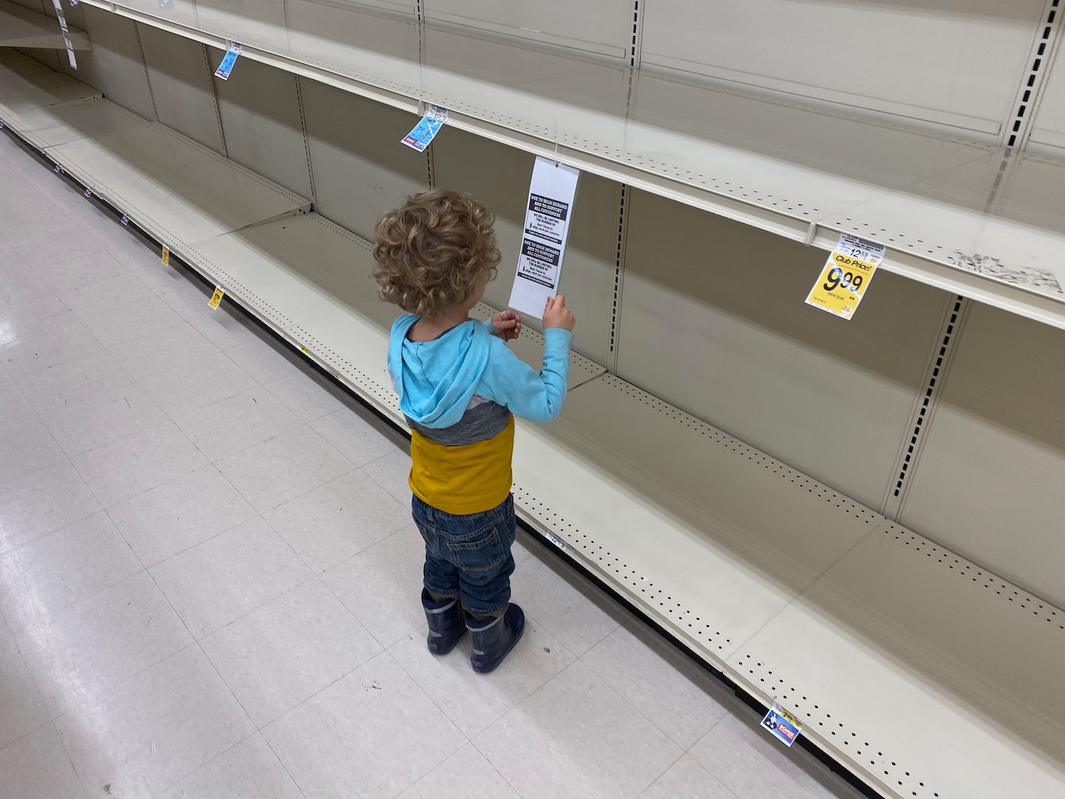 a child looking at a price tag on a shelf