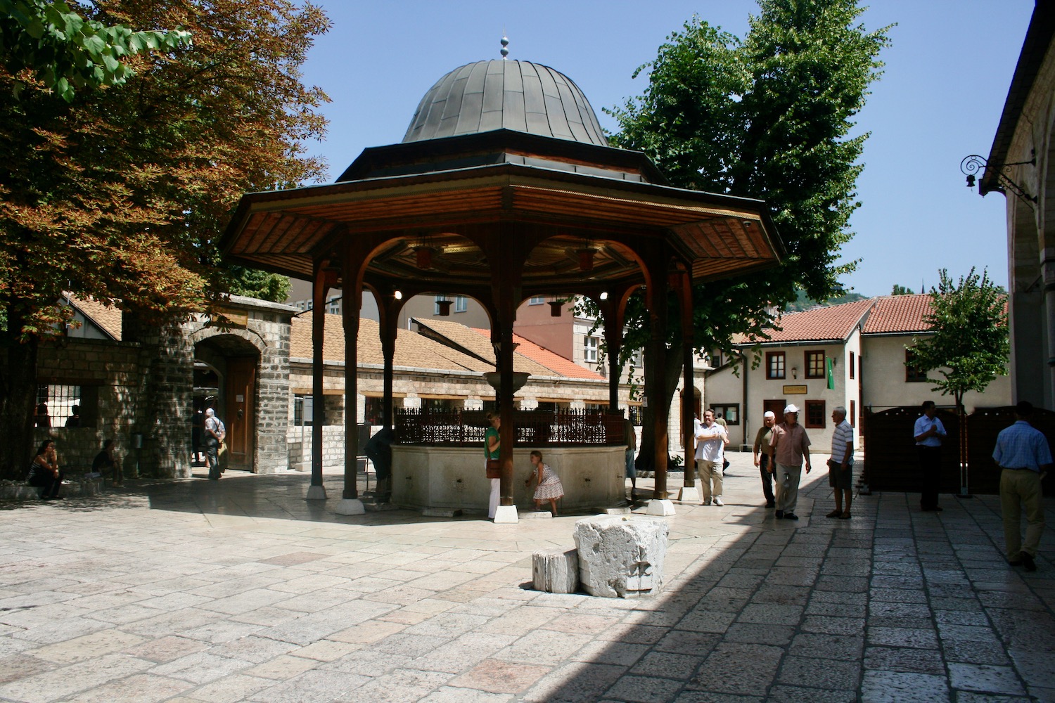 a group of people walking around a gazebo