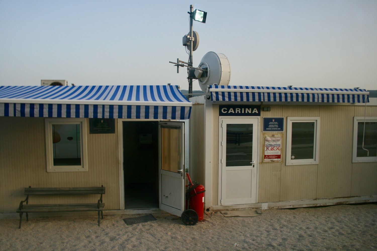 a small building with a door open and a satellite dish on the side