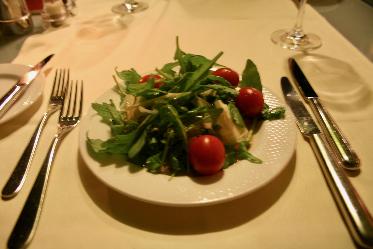 a plate of salad with tomatoes and greens
