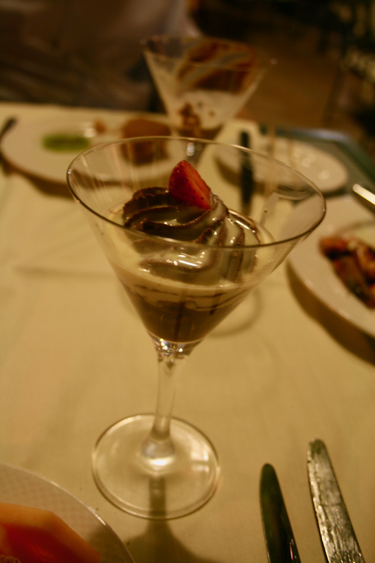 a glass of chocolate dessert with a strawberry in it