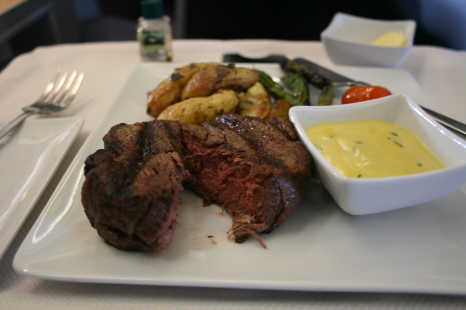 a plate of food with a cut piece of meat and potatoes