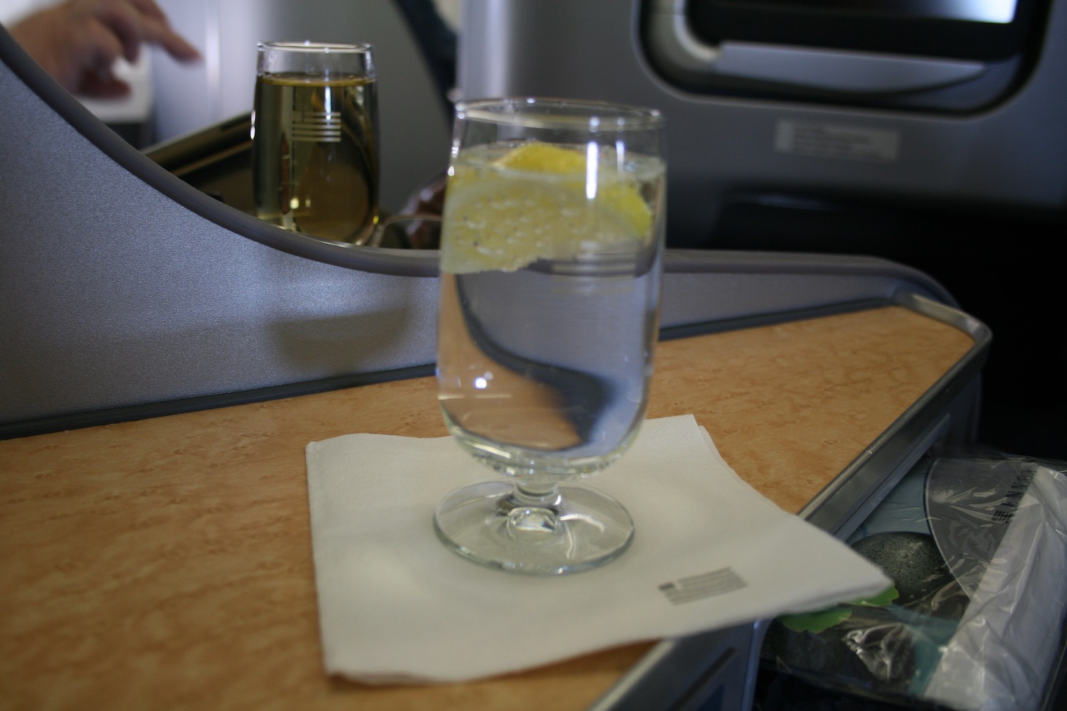 a glass of water with a lemon slice on a napkin