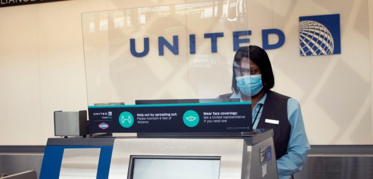 a woman wearing a face mask behind a screen