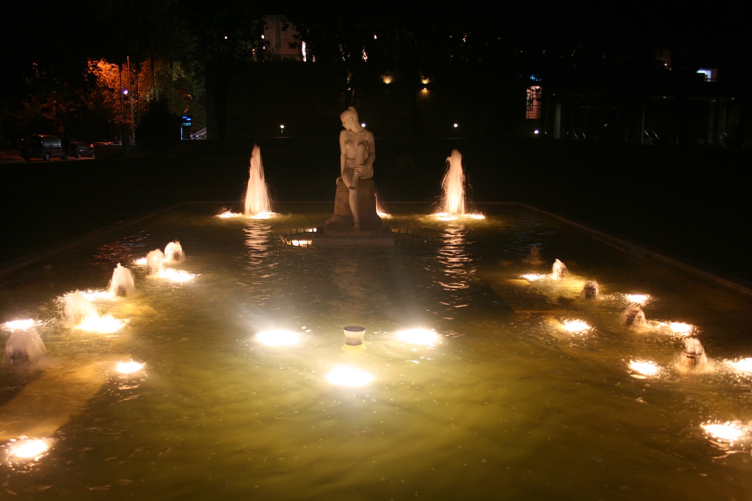 a statue in a fountain with lights