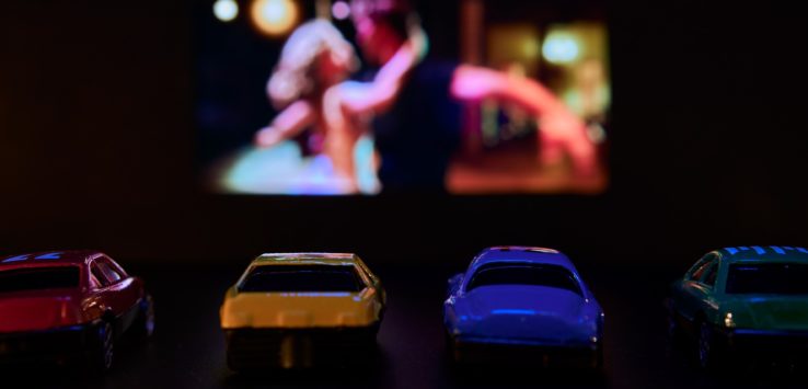 a group of toy cars in front of a television