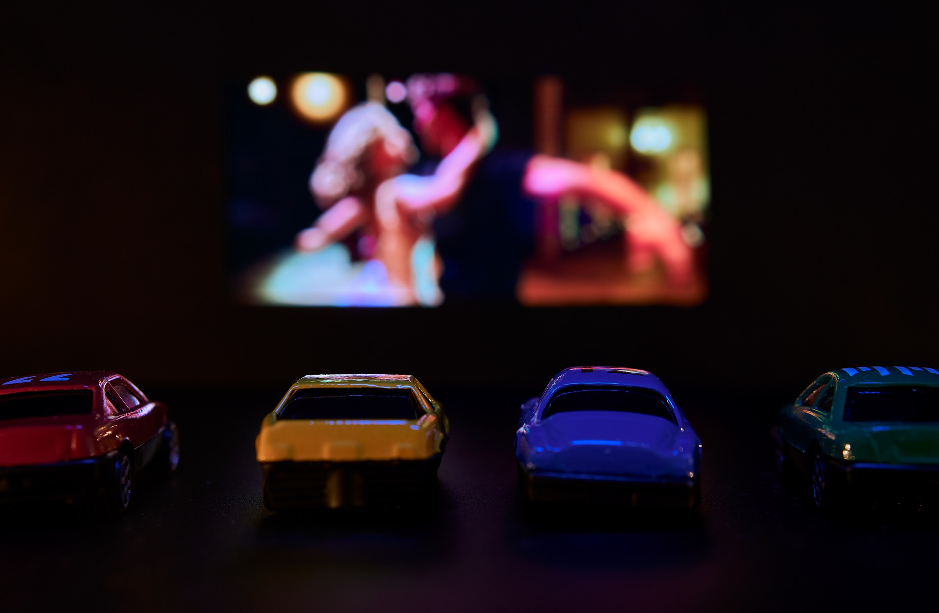 a group of toy cars in front of a television