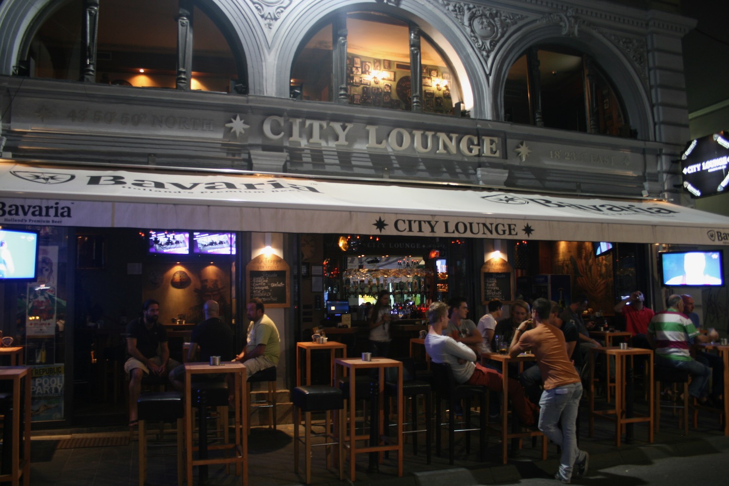 a group of people sitting at tables outside a building