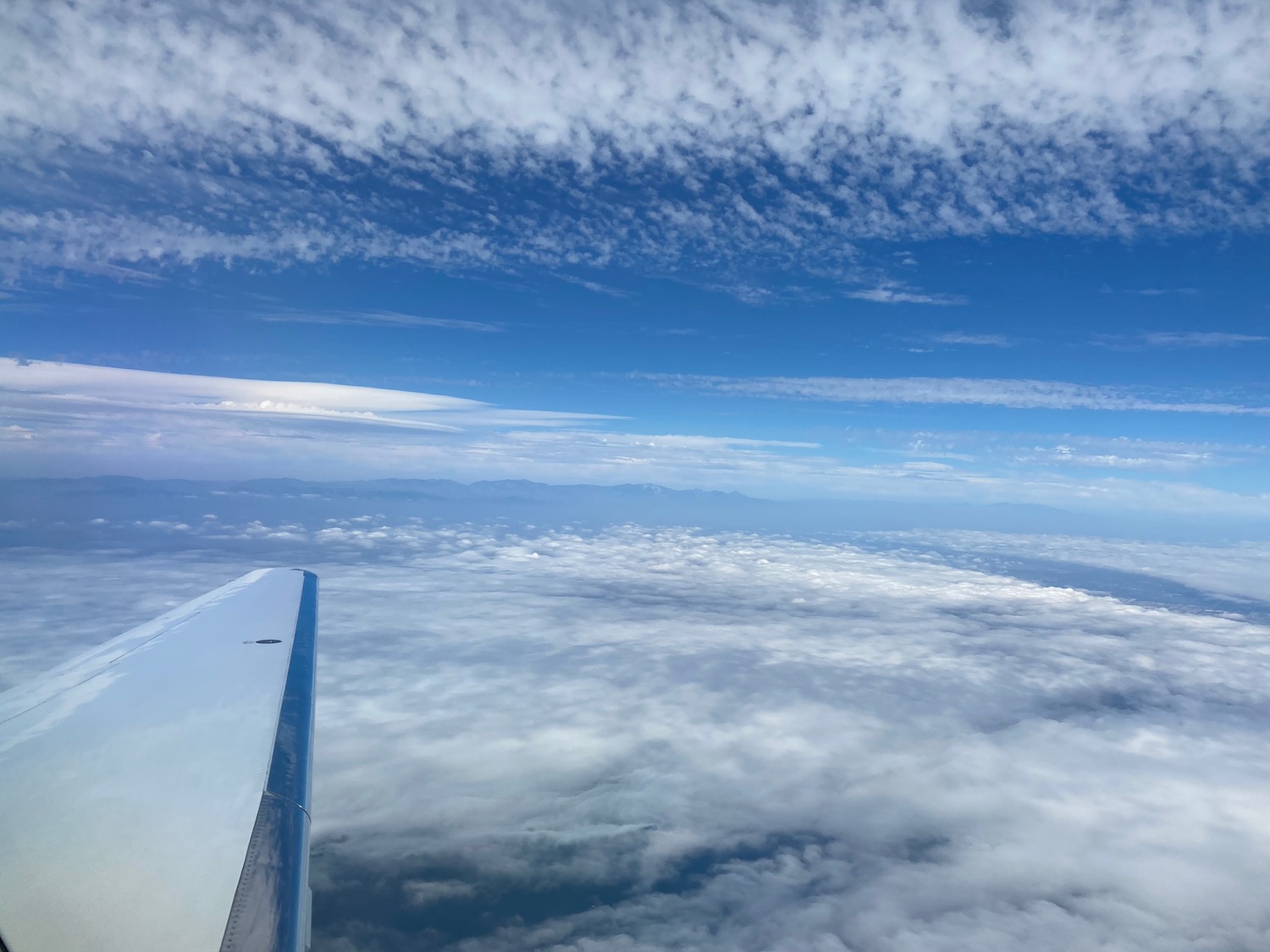 a wing of an airplane above clouds