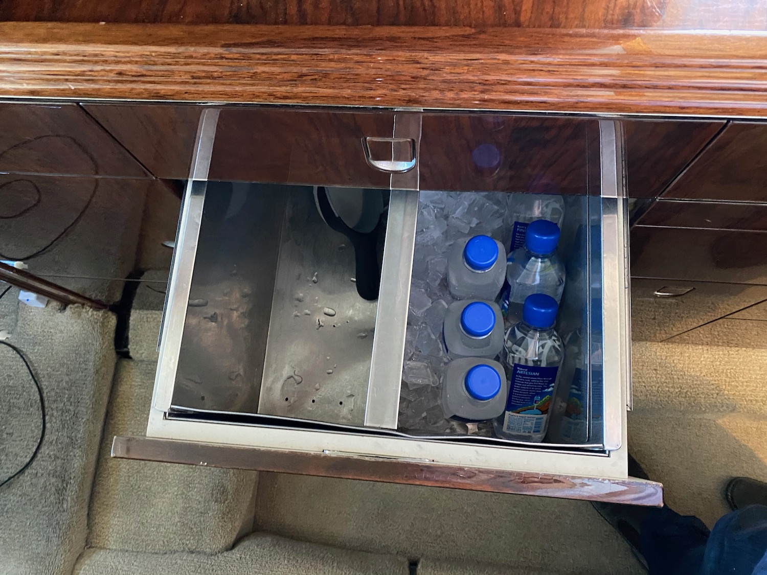 a drawer with bottles and water in it