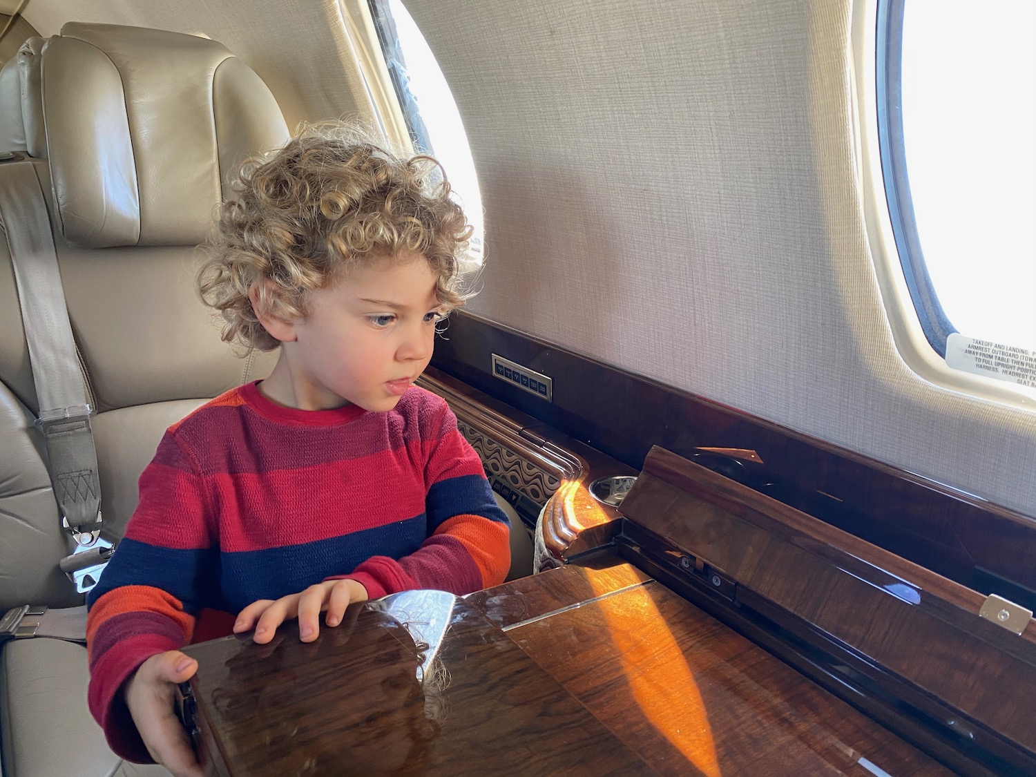 a child sitting in a chair in a plane