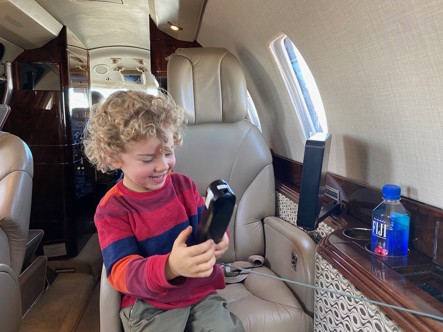 a child holding a phone in a plane