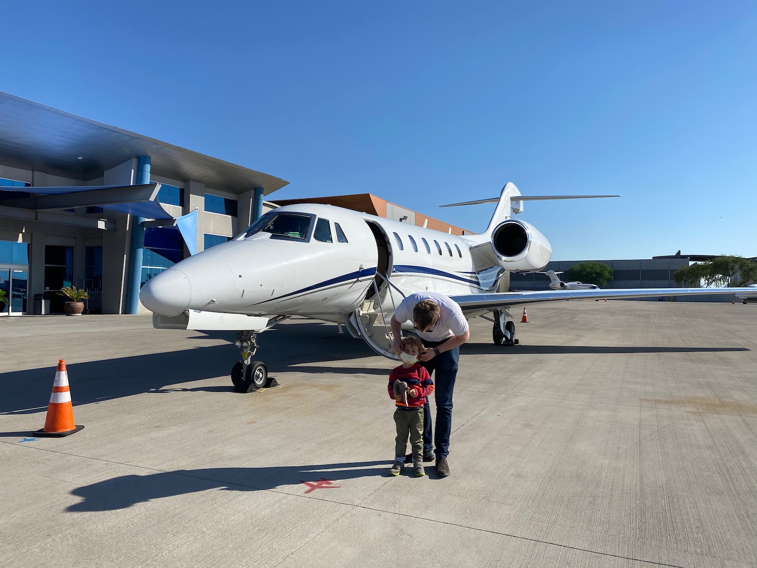 a man and child standing next to a plane