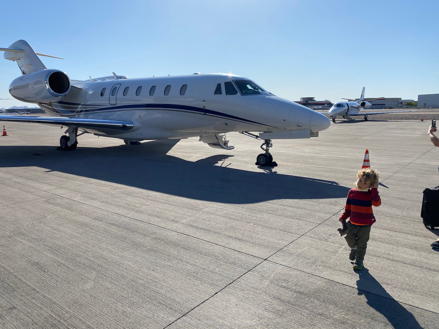 a child walking on a runway next to a plane