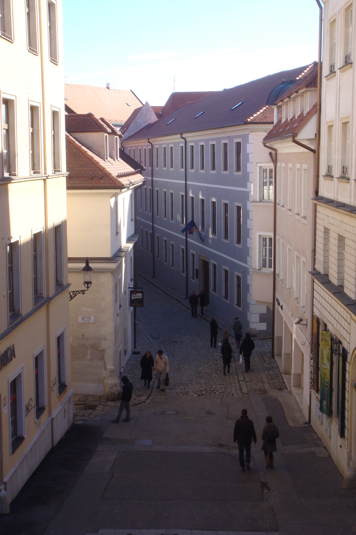 a group of people walking down a narrow street between buildings