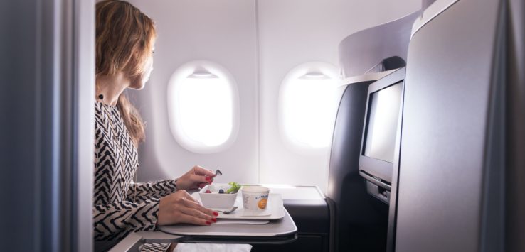 a woman eating food in an airplane