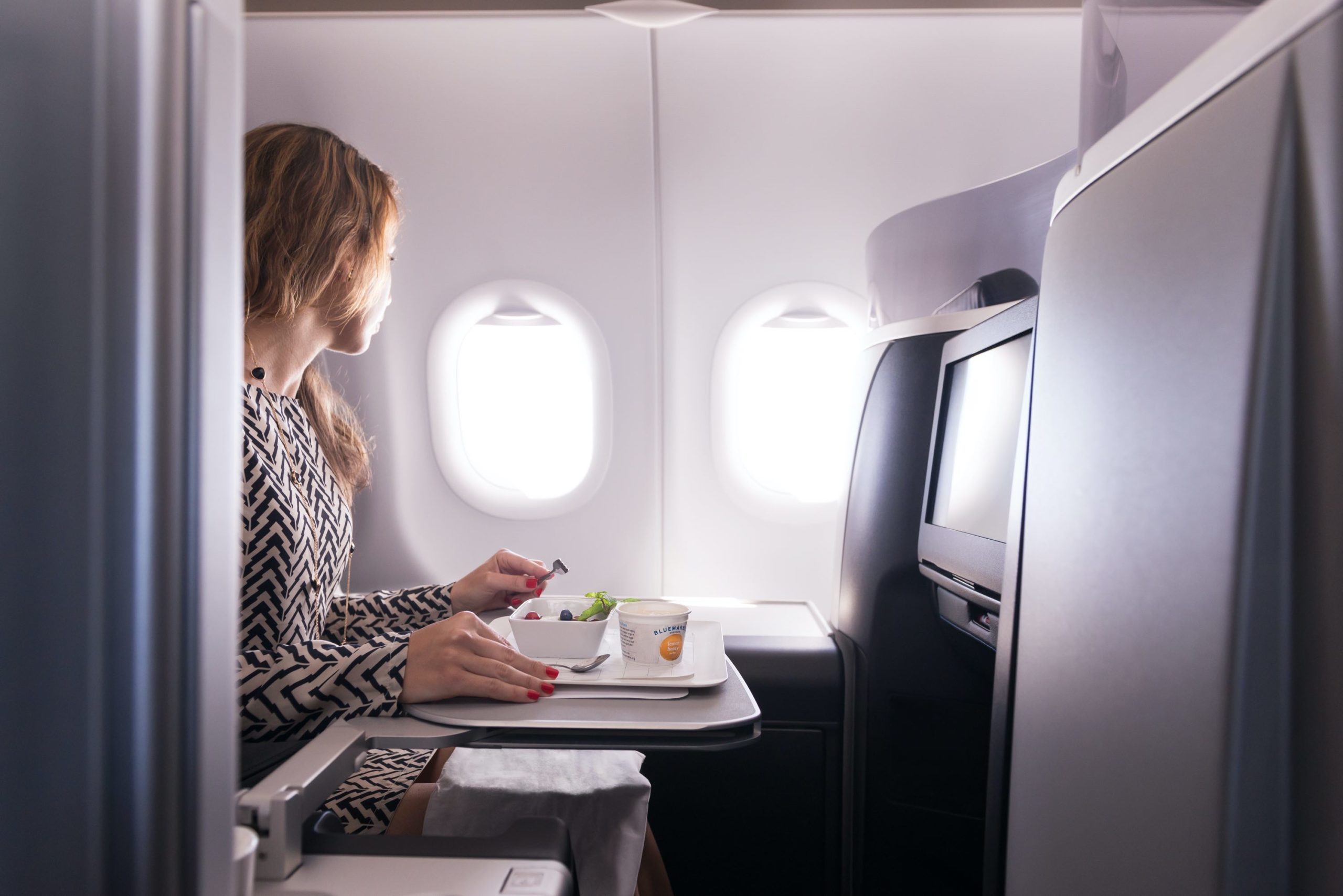 a woman eating food in an airplane