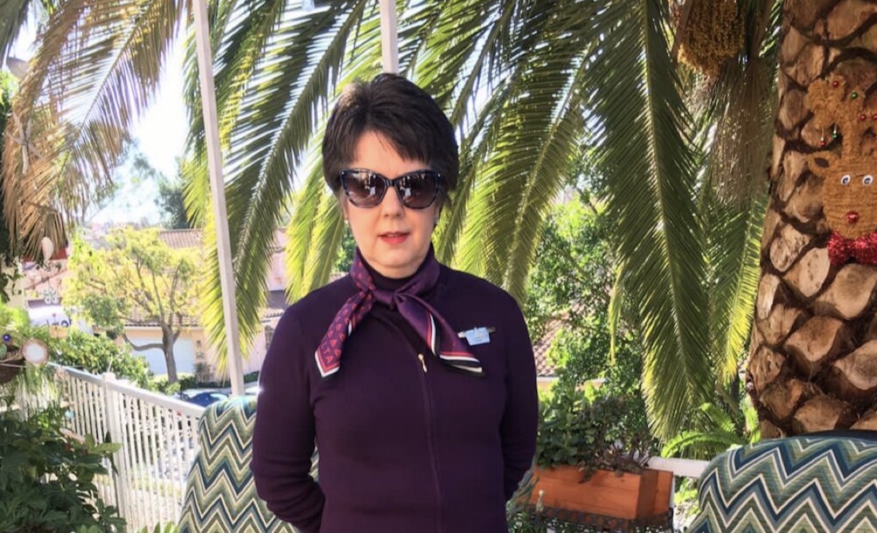 a woman standing under a palm tree