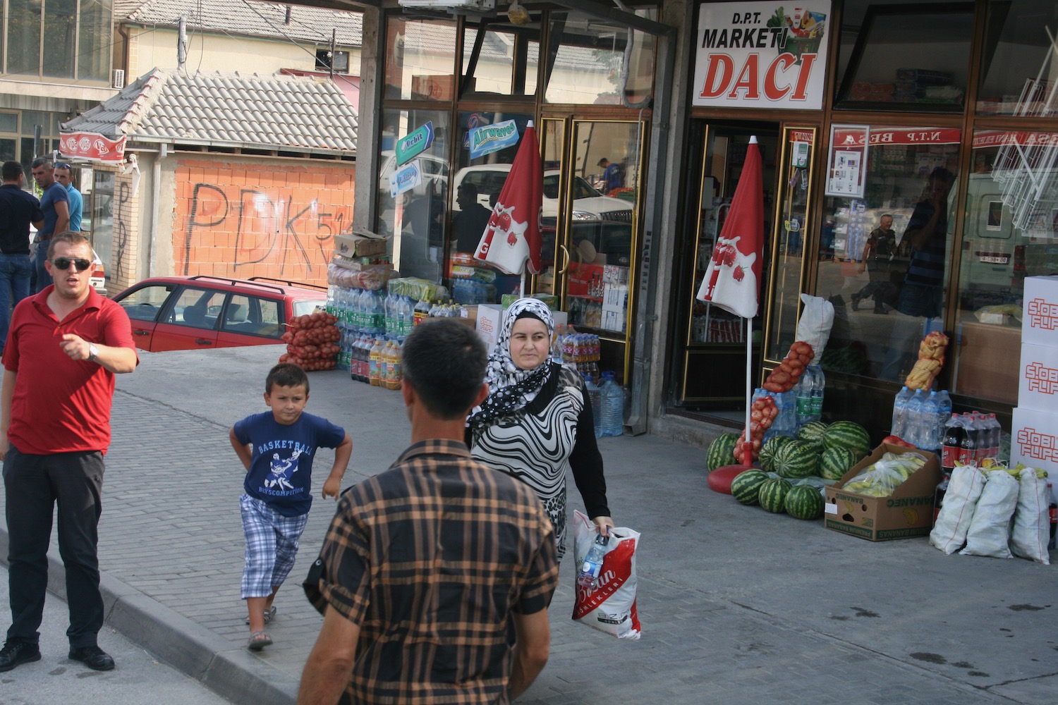 a woman and a boy walking on a sidewalk