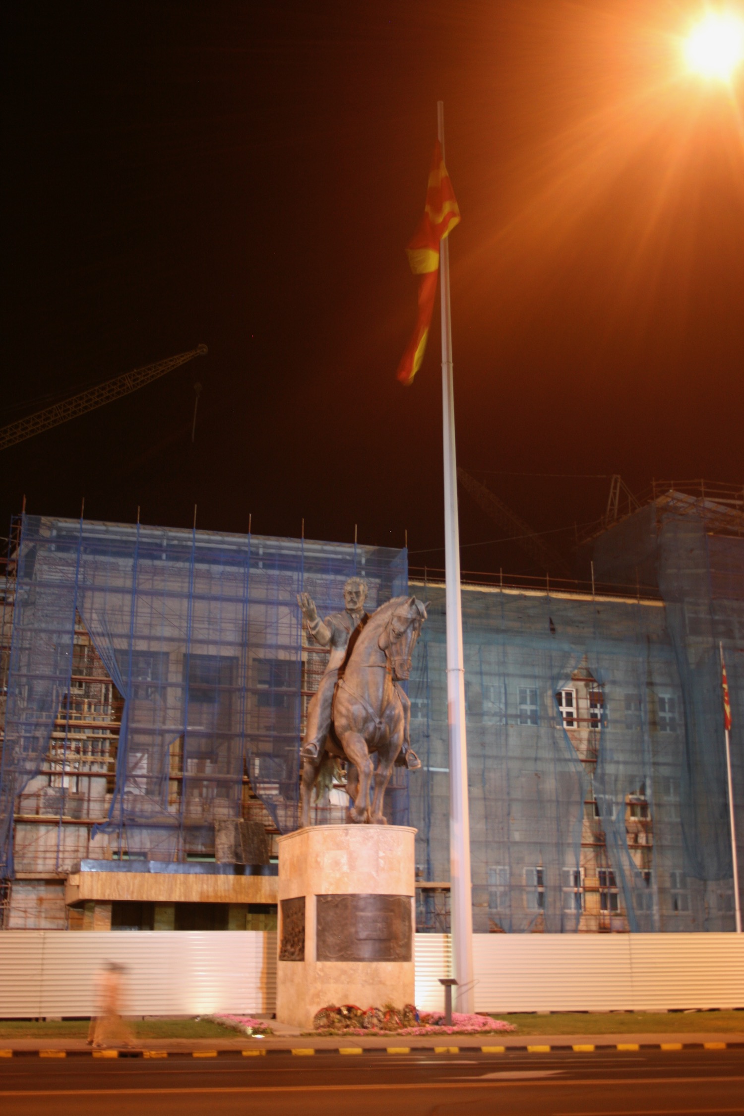 a statue of a man on a horse with a flag on a pole