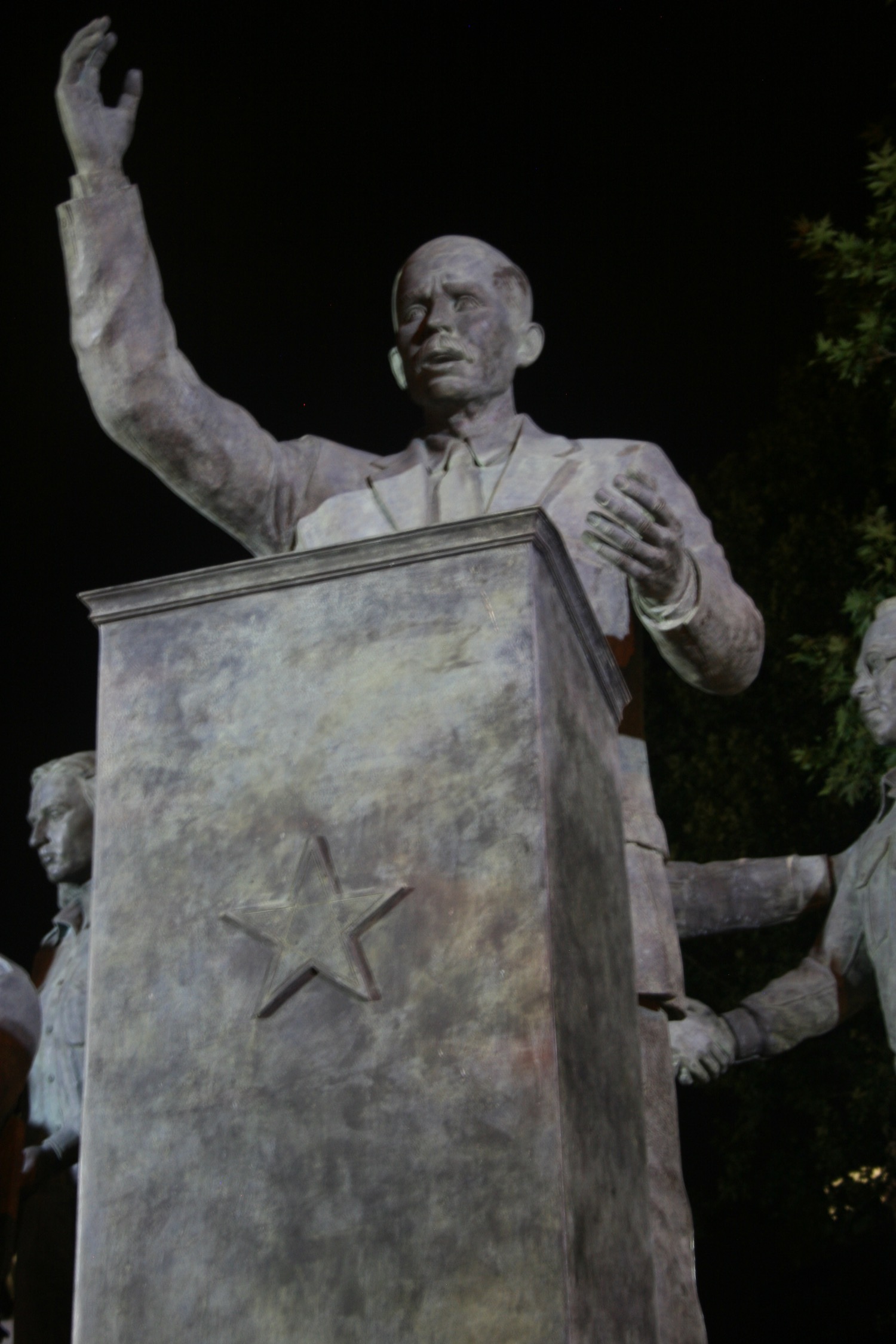 a statue of a man standing at a podium