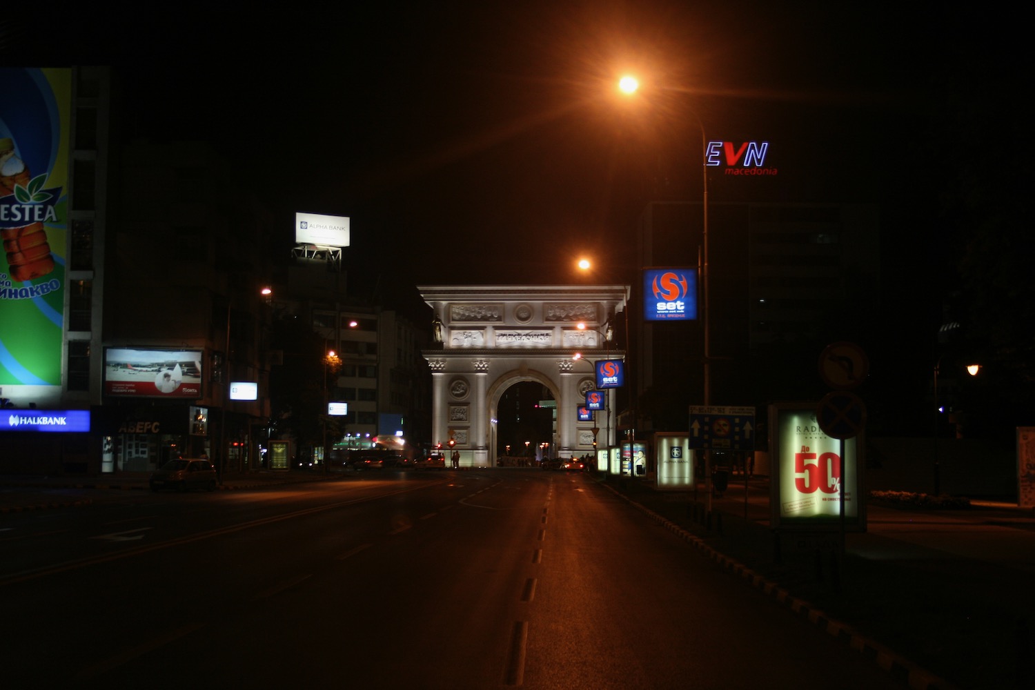 a street with a large archway and signs