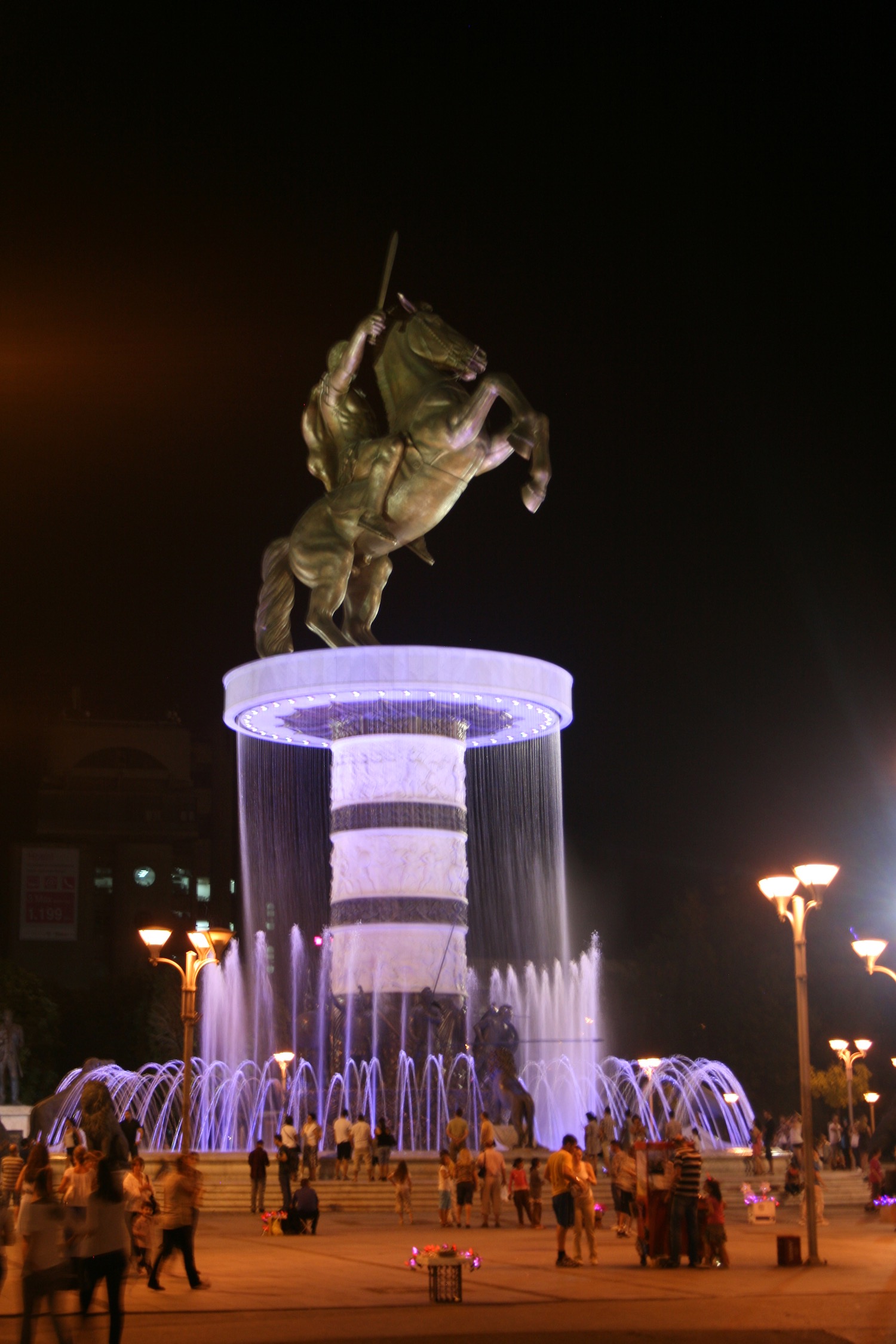 a statue of a man riding a horse on a pedestal with water fountain