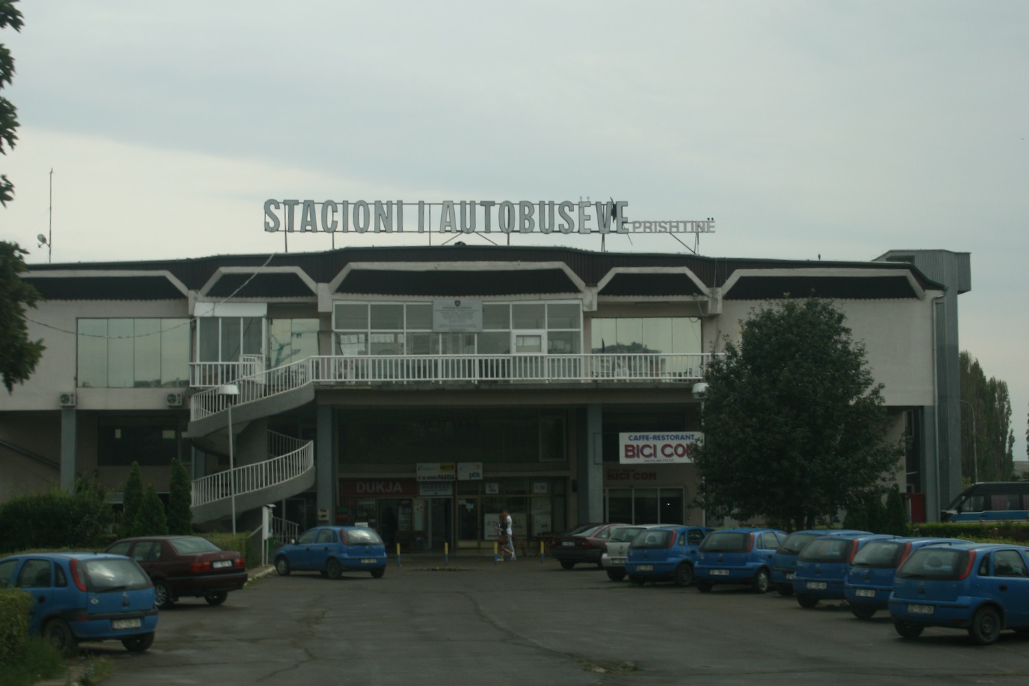 a building with a sign and cars parked in front of it