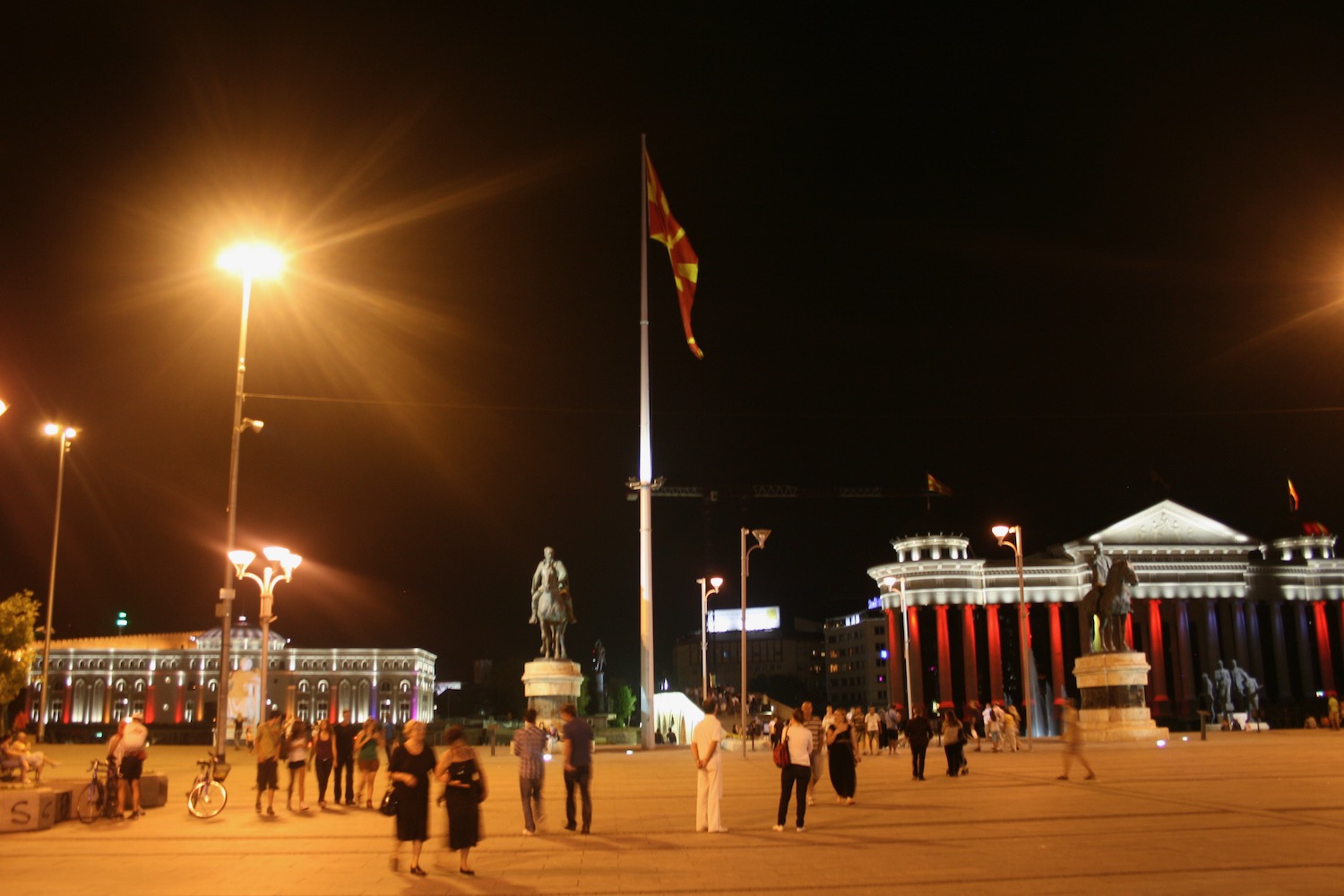 a group of people walking around a statue