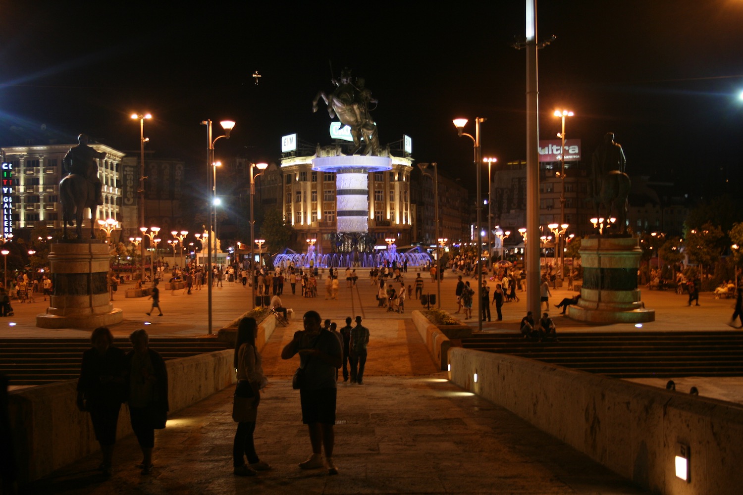 a group of people walking down a street at night