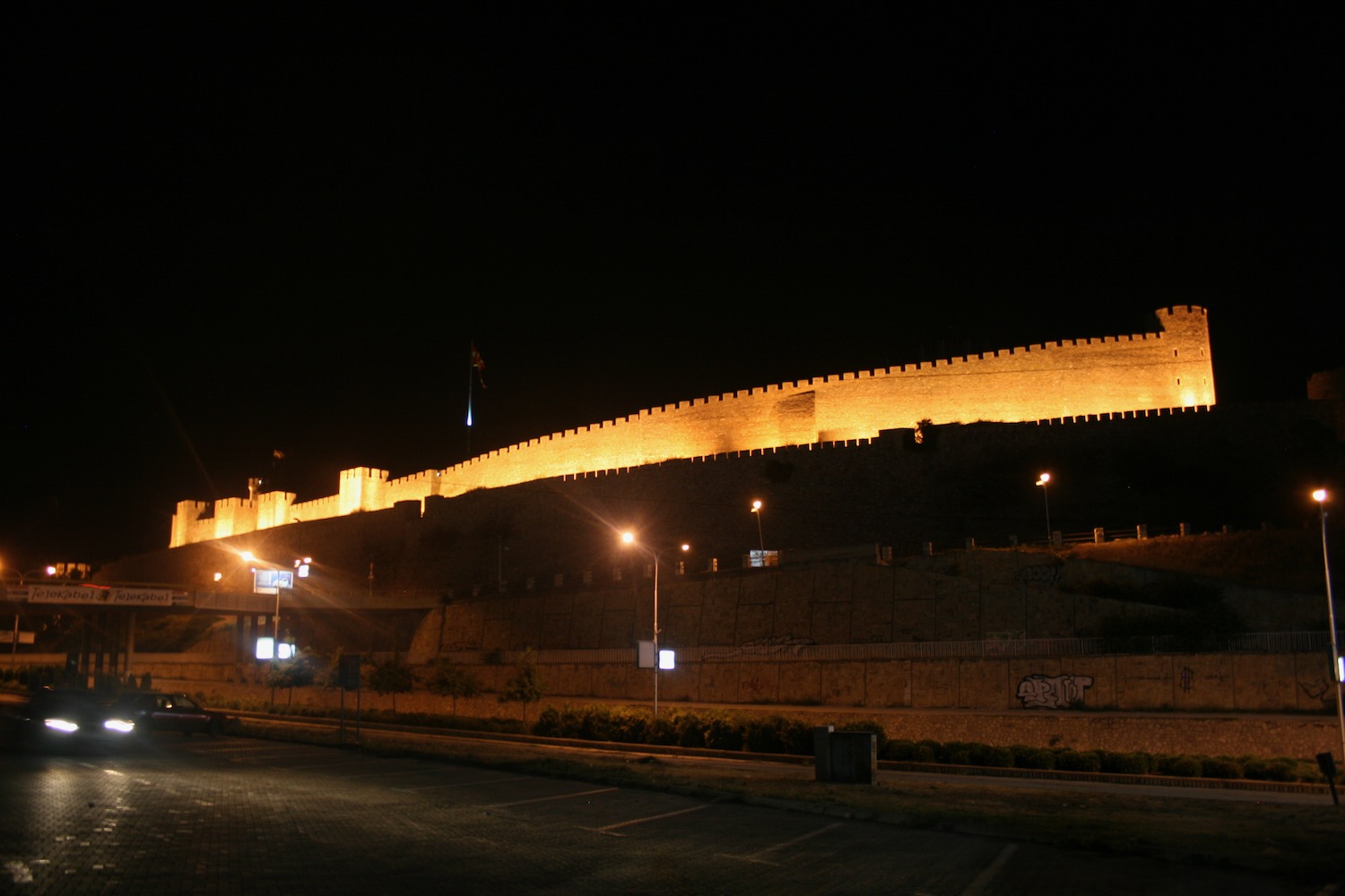 a large stone wall with lights at night