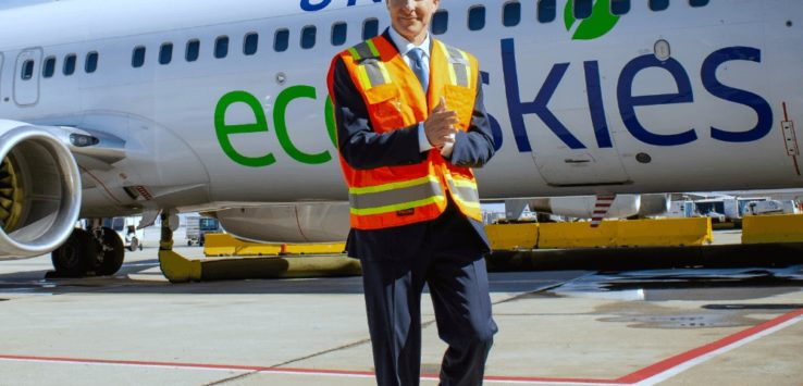 a man in a safety vest walking in front of an airplane