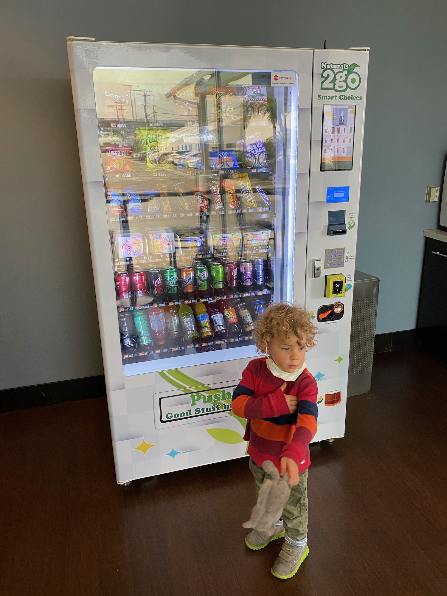 a child standing in front of a vending machine