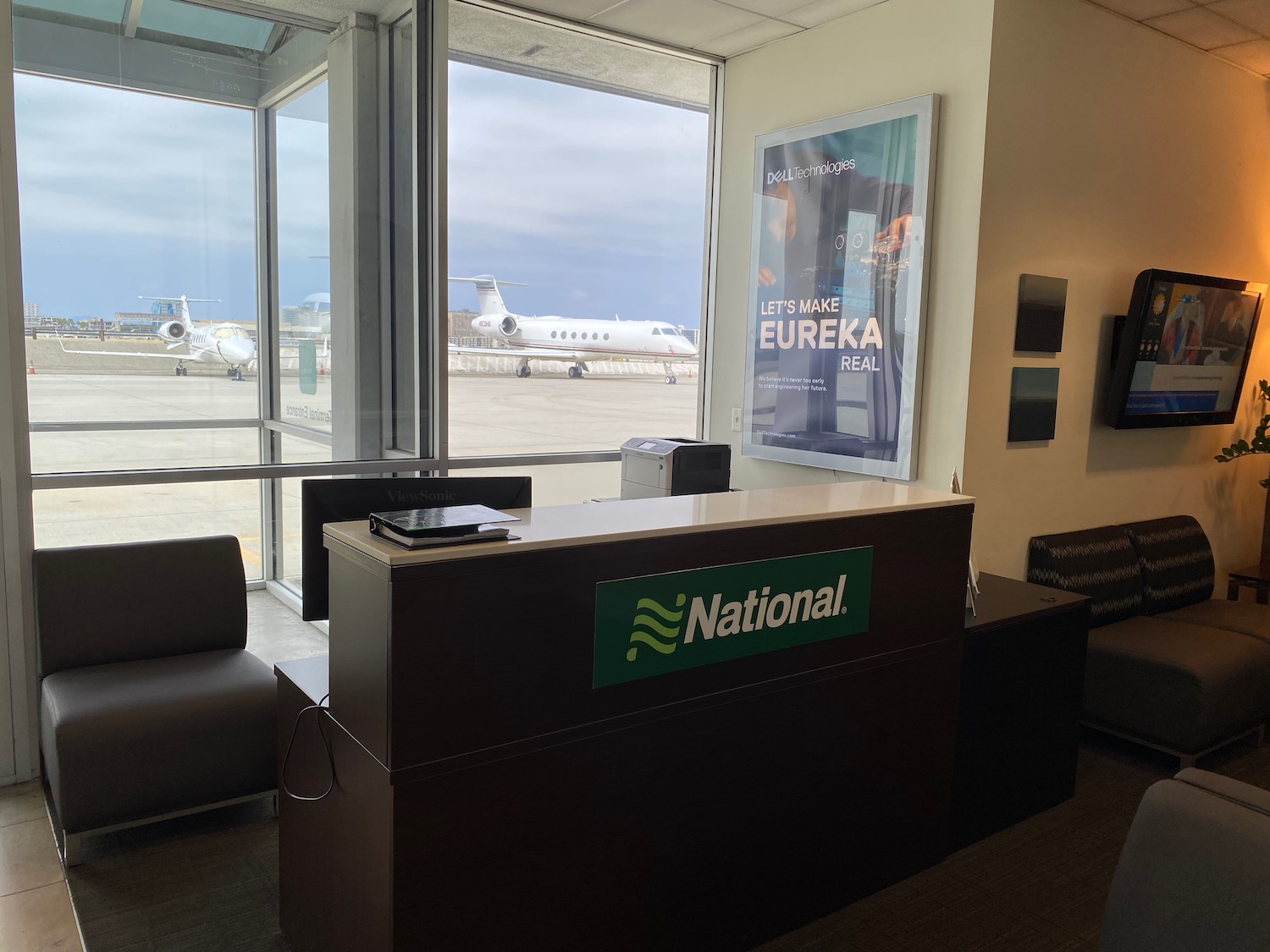 an airport reception desk with an airplane in the background