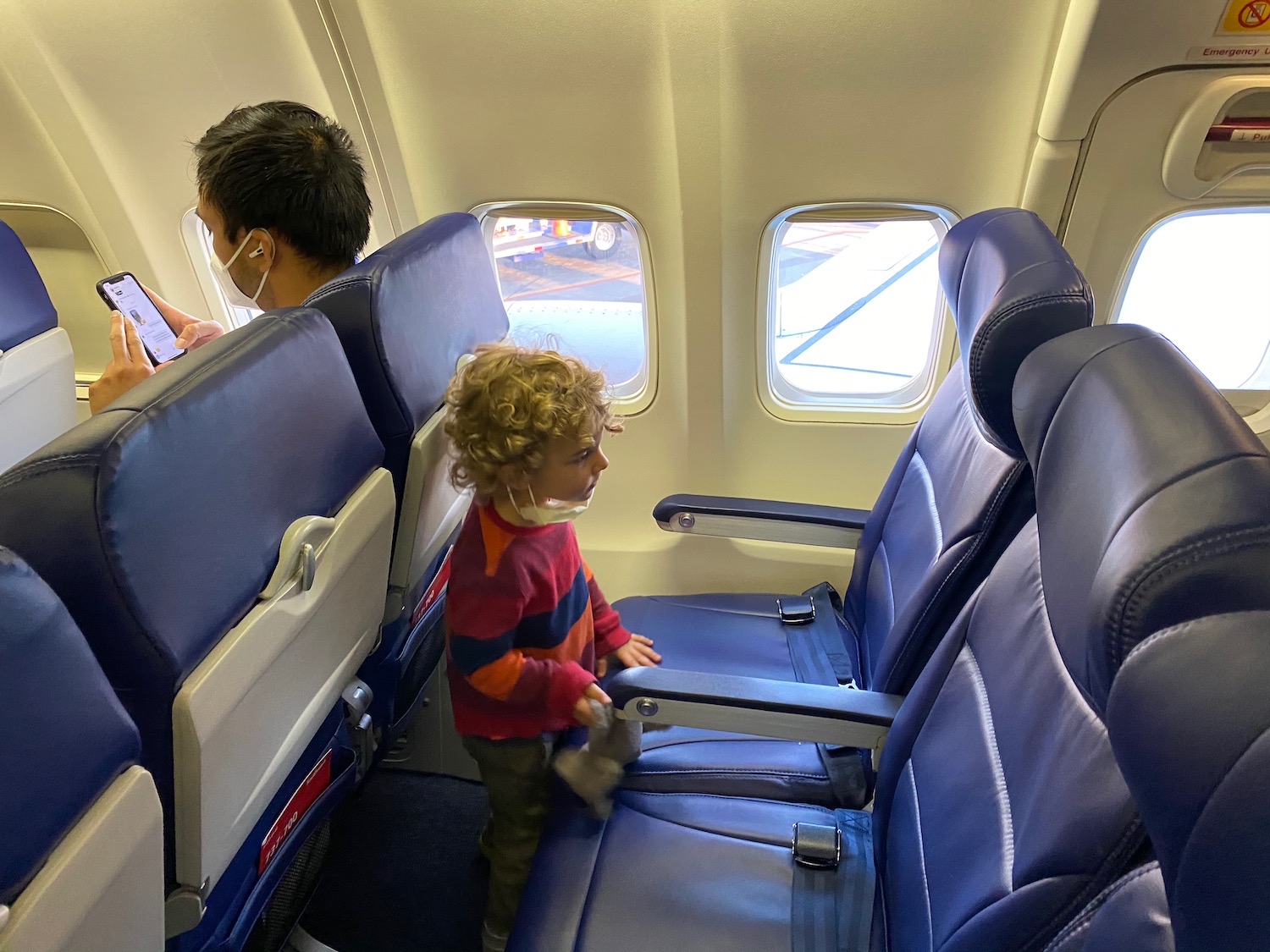 a child standing on a seat in an airplane