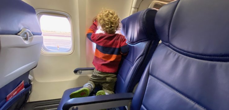 a child sitting on a seat in an airplane