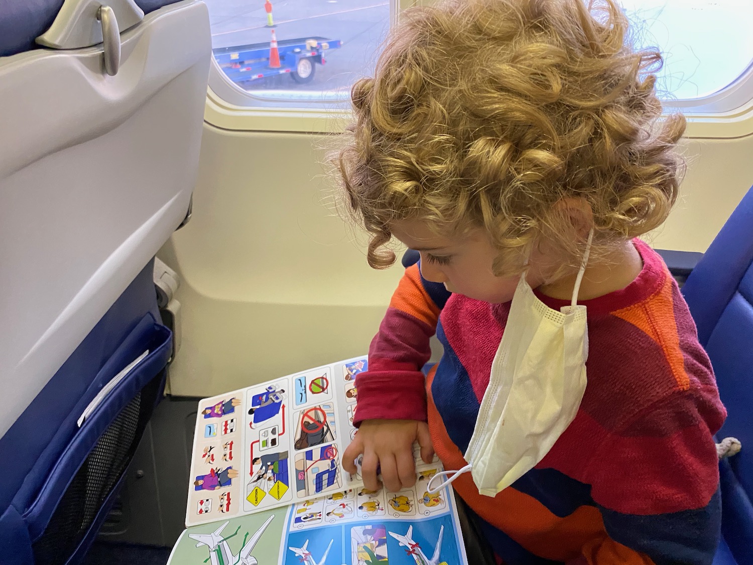 a child with a mask on reading a book