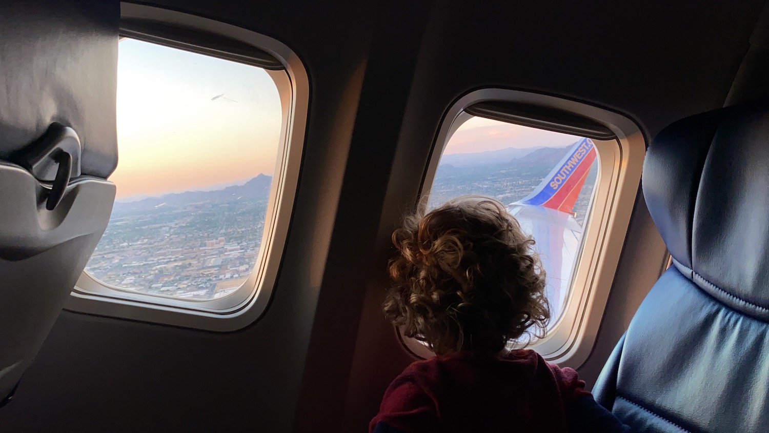 a child looking out the window of an airplane