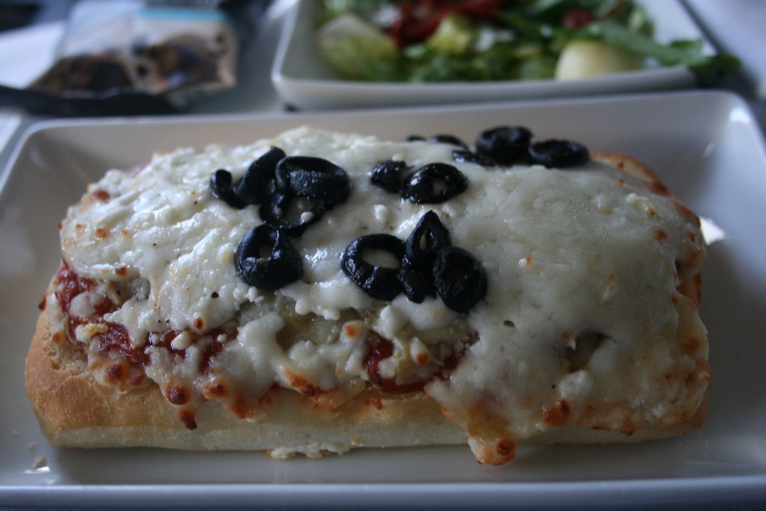 a sandwich with cheese and olives on top