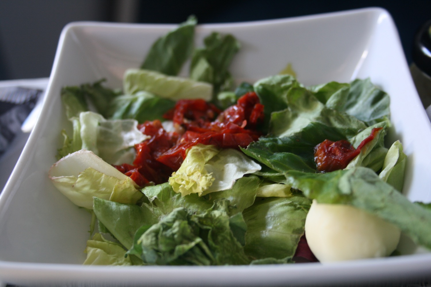 a bowl of salad with tomatoes and cheese